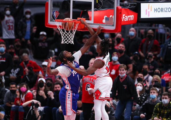 CHICAGO, IL - FEBRUARY 06: Chicago Bulls Guard Ayo Dosunmu (12) slam dunks the ball over Philadelphia 76ers Center Andre Drummond (1) during a NBA, Basketball Herren, USA game between the Philadelphia 76ers and the Chicago Bulls on February 6, 2022 at the United Center in Chicago, IL. (Photo by Melissa Tamez Icon Sportswire) NBA: FEB 06 76ers at Bulls Icon22020620