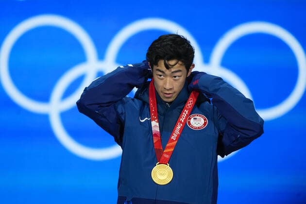Nathan Chen of the U.S. puts on his gold medal during the medals ceremony for the Men s Single Figure skating, Eiskunstlauf final at the Beijing 2022 Winter Olympics on Thursday, February 10, 2022. Chen won the gold medal, Yuma Kagiyama of Japan, the silver medal and Shoma Uno of Japan, the bronze medal.  OLY20220210306 PaulxHanna