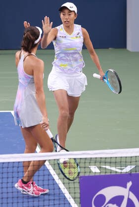 Zhang Shuai, CHN (cap, full white), and Ena Shibahara, JPN, during first round doubles of 2022 Dubai Championships in Dubai, 14 02 2022; -