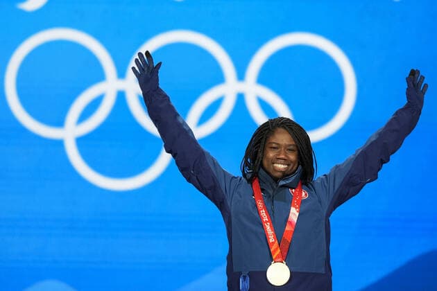 Erin Jackson of the U.S. wears her gold medal as she raises her arms during the medals ceremony for the Women s Speed skating, Eisschnelllauf 500 meter race at the Beijing 2022 Winter Olympics on Monday, February 14, 2022.  OLY20220214303 PaulxHanna