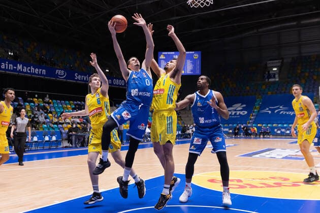 Fraport Skyliners - Alba Berlin, easyCredit-BBL Lukas Wank (Fraport Skyliners, 0) setzt sich gegen Malte Delow (Alba Berlin, 6) und Oscar da Silva (Alba Berlin, 1) durch. Rechts im Hintergrund lauert Jamel McLean (Fraport Skyliners, 1). Basketball-Spiel der easyCredit BBL zwischen den Fraport Skyliners und Alba Berlin am 15. Februar 2022 in der Ballsporthalle in Frankfurt am Main., Frankfurt am Main Hessen Deutschland Ballsporthalle