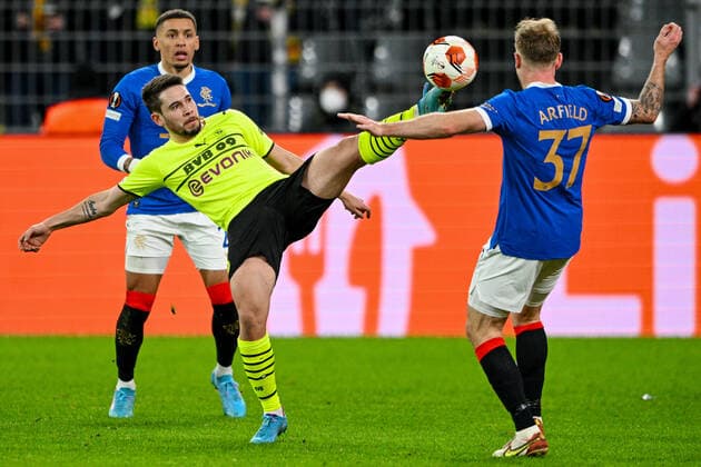 Europa League, Play-Off: Borussia Dortmund - Glasgow Rangers 17.02.2022 im Signal-Iduna-Park in Dortmund. Dortmund s Raphael Guerreiro im Zweikampf mit Glasgow s Scott Arfield ganze Figur, Copyright: xDavidxInderliedx