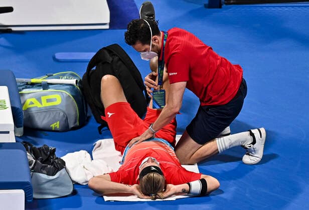 (220218) -- DOHA, Feb. 18, 2022 -- Alejandro Davidovich Fokina of Spain receives medical help during the quarterfinal of ATP, Tennis Herren Qatar Open Tennis match against Roberto Bautista Agut of Spain at International Tennis Complex in Doha, capital of Qatar, Feb. 17, 2022. (Photo by Xinhua) (SP)QATAR-DOHA-TENNIS-ATP QATAR OPEN-QUARTERFINAL Nikku 