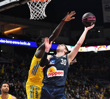 Basketball, Herren, Saison 2021 2022, MagentaSport BBL Pokal, Top Four (Finale), Hakro Merlins Crailsheim - Alba Berlin, v. l. Christ Koumadje (Alba Berlin), Jon Axel Gudmundsson (Hakro Merlins Crailsheim), 20.02. 2022, Copyright: xSebastianxRäppold MatthiasxKochx