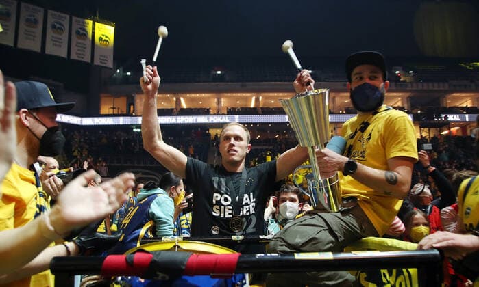 Pokalsieger Luke Sikma feiert und trommelt mit den Fans jubelnd Freude Emotion Jubel nach Spielende Basketball BBL Pokal Top Four Herren Finale Saison 2021 2022 20.02.2022 Alba Berlin vs. HAKRO Merlins Crailsheim