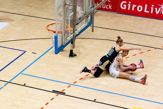 Basketball - DBBL - 18. Spieltag GiroLive Panthers Osnabrück - TK Hannover am 23.02.2022 in der OSC Halle in Osnabrück Milica Cuic (Panthers Osnabrueck) sitzt am Boden während Sasha Tarasava (Hannover) sie verteidigt