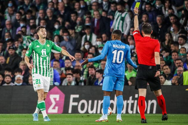 SEVILLE, SPAIN â€“ FEBRUARY 24, 2022: Zenit St Petersburg s Malcom (C) looks on as Betis s Guido Rodriguez (L) is shown a yellow card in the second leg of a UEFA Europa League playoff fooball match between Betis and Zenit St Petersburg at Benito Villamarin Stadium. Alexander Demianchuk TASS  TS1254CA