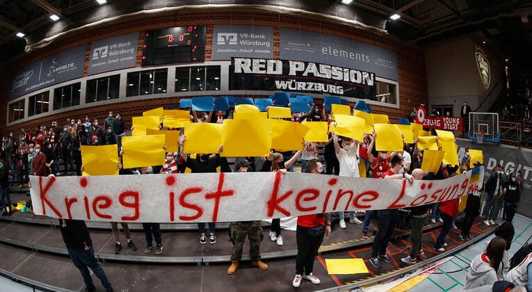 04.03.2022, Basketball, BBL, Hauptrunde, s.Oliver Wuerzburg - ratiopharm ulm, GER, Wuerzburg, tectake Arena Bild: v. li. Fans von Ulm und Wuerzburg zeigen durch einen Banner Solidaritaet mit der Ukraine. Copyright: HMBxMedia xHeikoxBecker