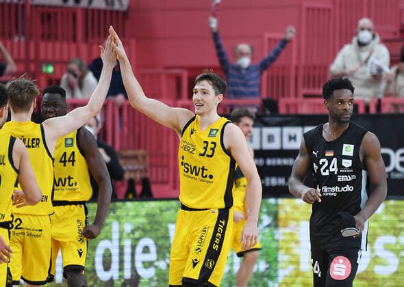 Basketball 2. Bundesliga 2020 2021 28. Spieltag in der Paul Horn Arena Tigers Tuebingen - Nuernberg Falcons 04.03.2022 JUBEL Tigers; Ryan Richard Mikesell (Mitte) klatscht Timo Lanmueller (li) ab, Roland Nyama (re, Nuernberg) enttaeuscht