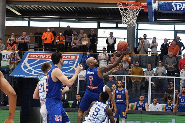 Basketball, 1. Bundesliga, Saison 2021 2022, Nachholspiel 15. Spieltag, SYNTAINICS MBC (Mitteldeutscher Basketball Club Weissenfels) vs. Fraport Skyliners Frankfurt Main (13.03.2022) Sergio Kerusch (Forward MBC Weissenfels, Rueckennummer 7) am Korb mit einem Korbleger gegen Brancou Badio (Guard Skyliners Frankfurt, Rueckennummer 8) beim Spiel Weißenfels gegen Fraport Skyliners Frankfurt (13. 03. 2022) Weißenfels Sachsen-Anhalt Deutschland Stadthalle Weißenfels