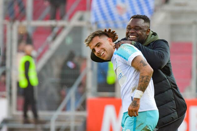 Schalker Urgestein Gerald Asamoha freut sich nach dem Spiel sichtlich ueber den Sieg seiner Mannschaft mit Rodrigo Zalazar (Schalke 04, Nr.10) beim Spiel FC Ingolstadt 04 gegen Schalke 04 am 13.03.2022, DFL regulations prohibit any use of photographs as image sequences and or quasi-video. GER, Fussball, 2. Bundesliga, Spieltag 26, FC Ingolstadt 04 gegen Schalke 04, 13.03.2022, Audi Sportpark Ingolstadt