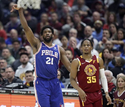 Philadelphia 76ers Joel Embiid (21) stands next to Cleveland Cavaliers Isaac Okoro (35) as he watches his shot go in for three points at Rocket Mortgage Field House in Cleveland, Ohio on Wednesday, March 16, 2022.  CLE202203161102 AARONxJOSEFCZYK