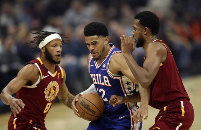 Philadelphia 76ers Tobias Harris (12) attempts to get a shot off between Cleveland Cavaliers Lamar Stevens (8) and Evan Mobley (4) at Rocket Mortgage Field House in Cleveland, Ohio on Wednesday, March 16, 2022.  CLE202203161122 AARONxJOSEFCZYK