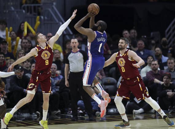 Philadelphia 76ers James Harden (1) puts up a shot between Cleveland Cavaliers Dylan Windler (9) and Kevin Love (0) at Rocket Mortgage Field House in Cleveland, Ohio on Wednesday, March 16, 2022.  CLE20220316112 AARONxJOSEFCZYK