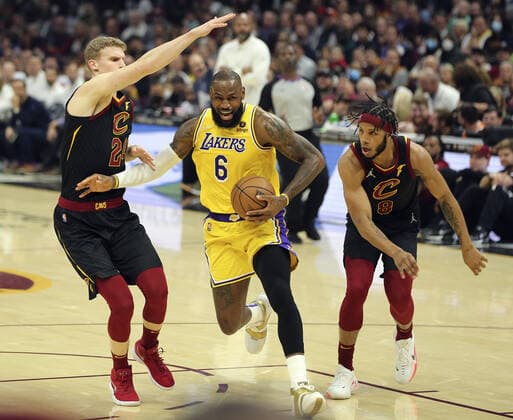Basketball, NBA, Cleveland Cavaliers - Los Angeles Lakers Los Angeles Lakers LeBron James (6) drives to the basket between Cleveland Cavaliers Lauri Markkanen (24) and Lamar Stevens (8) at Rocket Mortgage FieldHouse in Cleveland, Ohio on Monday, March 21, 2022.  CLE20220321110 AARONxJOSEFCZYK