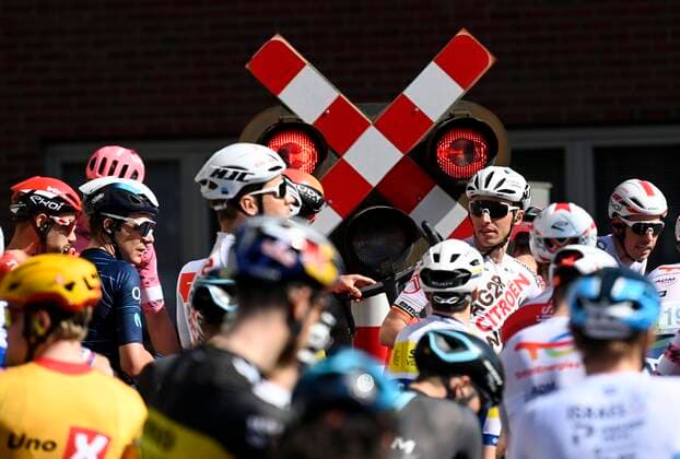 Sport Themen der Woche KW12 HARELBEKE, BELGIUM - MARCH 25 : Illustration picture of the peloton stopped by the train during the 65th Saxo Bank classic E3 Harelbeke UCI World Tour cycling race with start and finish in Harelbeke on March 25, 2022 in Harelbeke, Belgium, 25 03 2022 ( Motordriver Kenny Verfaillie & 2022 E3 Harelbeke cycling race PhotoNews Panoramic 