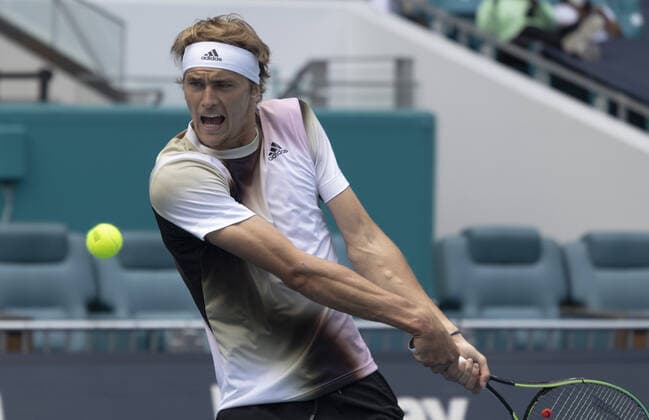 Alexander Zverev from Germany returns a two handed backhand shot to Borna Coric from Croatia at the Miami Open in the Hard Rock Stadium in Miami Gardens, Florida, on Friday, March 25, 2022. Zverev defeated Coric 6-4, 3-6, 6-4 in three sets.  MIA20220325119 GARYxIxROTHSTEIN
