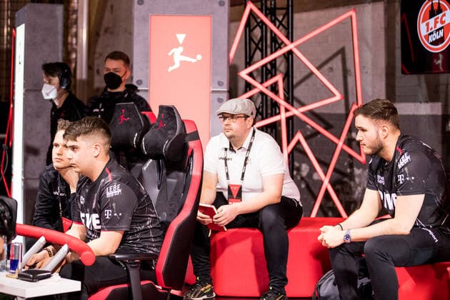 bevestor Virtual Bundesliga Club Championship Finals; 26.03.2022 Denis Denis Mueller (1. FC Koeln) im Match, Peter Petkus Schwab (1. FC Koeln) und Tim TheStrxngeR Katnawatos (1. FC Koeln) im Hintergrund bevestor Virtual Bundesliga Club Championship Finals Tag 1; Strassenkickerbase, Koeln DFL REGULATIONS PROHIBIT ANY USE OF PHOTOGRAPHS AS IMAGE SEQUENCES AND OR QUASI-VIDEO.