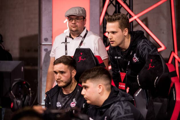 bevestor Virtual Bundesliga Club Championship Finals; 26.03.2022 Tim TheStrxngeR Katnawatos (1. FC Koeln) und Denis Denis Mueller (1. FC Koeln) im Match, Peter Petkus Schwab (1. FC Koeln) und Lukas Idealz Schmandt (Coach 1. FC Koeln) im Hintergrund bevestor Virtual Bundesliga Club Championship Finals Tag 1; Strassenkickerbase, Koeln DFL REGULATIONS PROHIBIT ANY USE OF PHOTOGRAPHS AS IMAGE SEQUENCES AND OR QUASI-VIDEO.