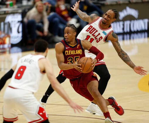 Cleveland Cavaliers guard Isaac Okoro (C) drives to the basket between Chicago Bulls guard Zach LaVine (L) and Chicago Bulls forward DeMar DeRozan (R) during the second half of the NBA, Basketball Herren, USA game between the Cleveland Cavaliers and the Chicago Bulls at Rocket Mortgage Fieldhouse in Cleveland, Ohio, USA, 26 March 2022. Chicago Bulls at Cleveland Cavaliers !ACHTUNG: NUR REDAKTIONELLE NUTZUNG!  Copyright: xDAVIDxMAXWELLx AME6288 20220327-921f104d4b623986a9e319a97f238bef953399b4