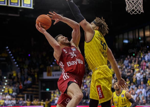 Oldenburg, Niedersachsen, DEU, 02.04.2022, Gavin Schilling (links, FC Bayern Basketball) und Reggie Lynch (rechts, EWE Baskets Oldenburg). EWE Baskets Oldenburg vs. FC Bayern Basketball. 1. Basketball-Bundesliga Saison 2021 2022, 28. Spieltag, Grosse EWE Arena. EWE Baskets Oldenburg vs. FC Bayern Basketball