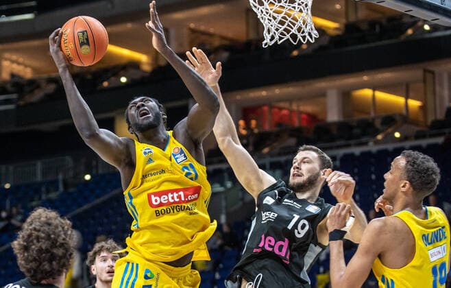 04.04.2022, Berlin, Basketball, 1. Bundesliga, easyCredit BBL, Hauptrunde, 28.Spieltag, Mercedes Benz Arena: ALBA Berlin - Medi Bayreuth. ALBAs Christ Koumadje (l) springt zum Korb gegen Martynas Sajus von Medi Bayreuth. ALBA Berlin - Medi Bayreuth