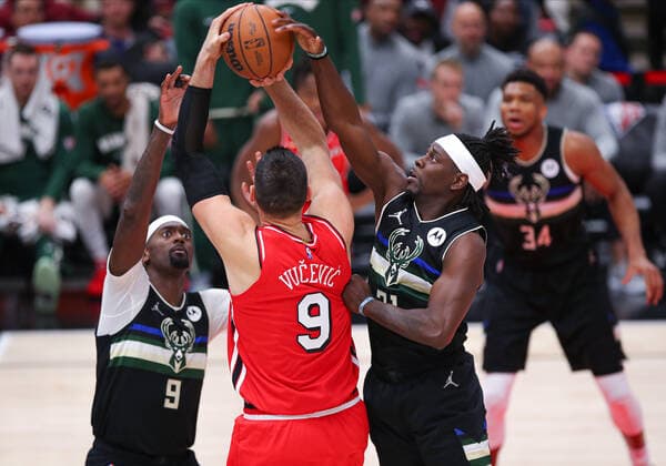 CHICAGO, IL - APRIL 05: Milwaukee Bucks guard Jrue Holiday (21) blocks Chicago Bulls center Nikola Vucevic (9) shoot in action during a NBA, Basketball Herren, USA game between the Milwaukee Bucks and the Chicago Bulls on April 5, 2022 at the United Center in Chicago, IL. (Photo by Melissa Tamez Icon Sportswire) NBA: APR 05 Bucks at Bulls Icon22040515