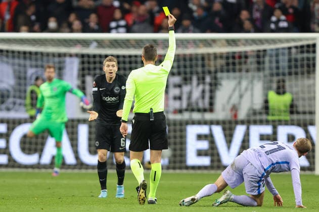 Eintracht Frankfurt - FC Barcelona, Barca UEFA Europa League Schiedsrichter Srdjan Jovanovic (Serbien) zeigt Kristijan Jakic (Eintracht Frankfurt, 6) die Gelbe Karte für ein Foul an Frenkie de Jong (FC Barcelona, 21). Viertelfinal-Hinspiel der UEFA Europa League zwischen Eintracht Frankfurt und dem FC Barcelona am 7. April 2022 im Deutsche Bank Park in Frankfurt am Main., Frankfurt am Main Hessen Deutschland Deutsche Bank Park