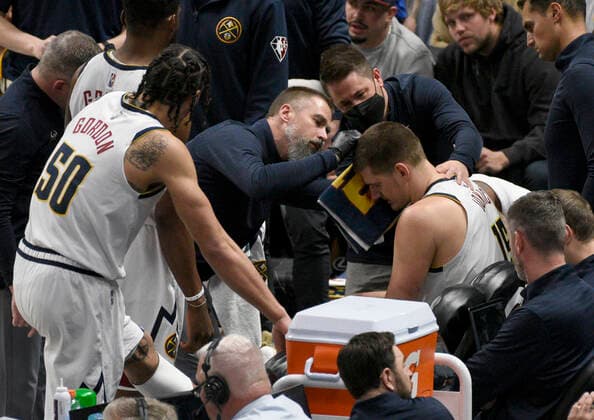 Denver Nuggets center Nikola Jokic 15, right sitting, gets attended to by the Denver Nuggets team doctor for an injury during a NBA, Basketball Herren, USA basketball game, at the Ball Arena, in Denver, US, 07 April 2022. EFE Todd Pierson Denver Nuggets vs. Memphis Grizzlies !ACHTUNG: NUR REDAKTIONELLE NUTZUNG!  Copyright: xToddxPiersonx AME9759 20220408-158d087f858fb3e272ba6dd9f29d31273037598b