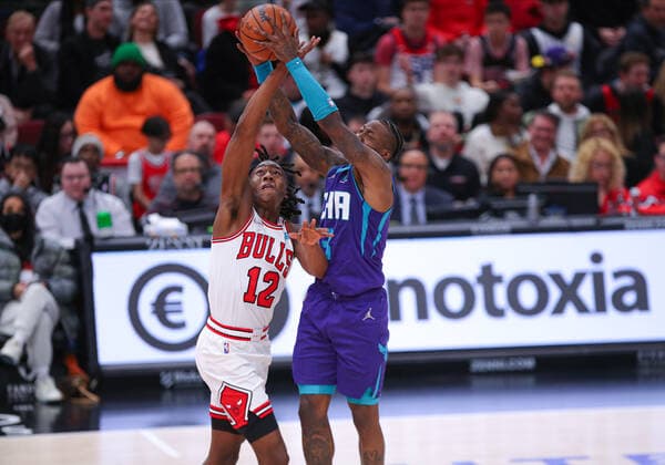 CHICAGO, IL - APRIL 08: Chicago Bulls guard Ayo Dosunmu (12) and Charlotte Hornets guard Terry Rozier (3) in action reaching for the ball during a NBA, Basketball Herren, USA game between the Charlotte Hornets and the Chicago Bulls on April 8, 2022 at the United Center in Chicago, IL. (Photo by Melissa Tamez Icon Sportswire) NBA: APR 08 Hornets at Bulls Icon22040841