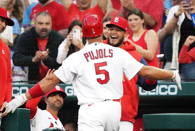 St. Louis Cardinals designated hitter Albert Pujols is hugged by Yadier Molina after hitting his 680 career home run in the first inning against the Kansas City Royals at Busch Stadium in St. Louis on Tuesday, April 12, 2022.  SLP2022041211 BILLxGREENBLATT