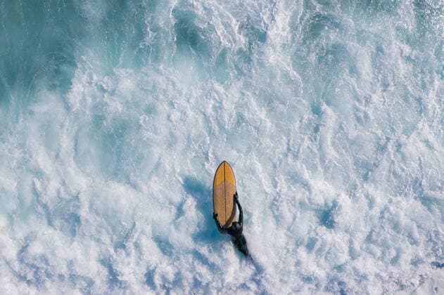 Bilder des Jahres 2022, Sport 04 April Sport Themen der Woche KW16 Sport Bilder des Tages VLADIVOSTOK, RUSSIA - APRIL 22, 2022: A surfer carries a surfboard in Chernysheva Bay of Ussuri Bay off Russky Island. Yuri Smityuk TASS  TS12DF36