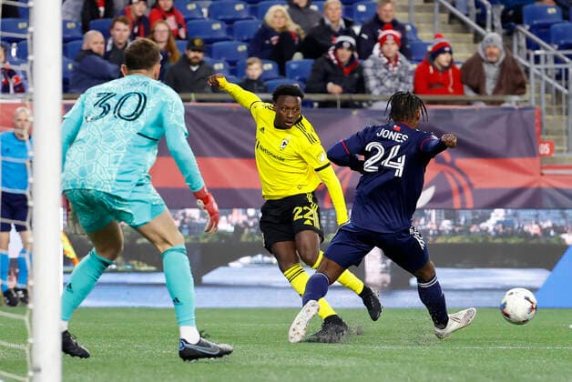 FOXBOROUGH, MA - MAY 07: Columbus Crew midfielder Derrick Etienne Jr. (22) crosses the ball past New England Revolution midfielder DeJuan Jones (24) during a match between the New England Revolution and the Columbus Crew on May 7, 2022, at Gillette Stadium in Foxborough, Massachusetts. (Photo by Fred Kfoury III Icon Sportswire) SOCCER: MAY 07 MLS, Fussball Herren, USA - Columbus Crew at New England Revolution Icon482220507005