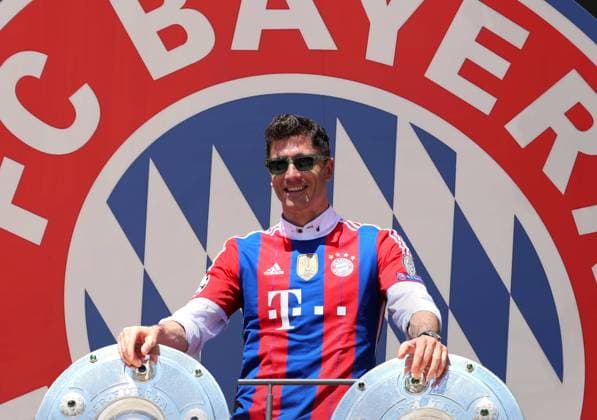 München, Deutschland 15. Mai 2022: Fussball, Herren, Saison 2021 2022, FC Bayern München, Robert Lewandowski Robert Lewandowski (FC Bayern München) in einer Fotomontage, als Symbolbild, bleibt er oder geht er ? Im Hintergrund das Logo, Wappen des Vereins