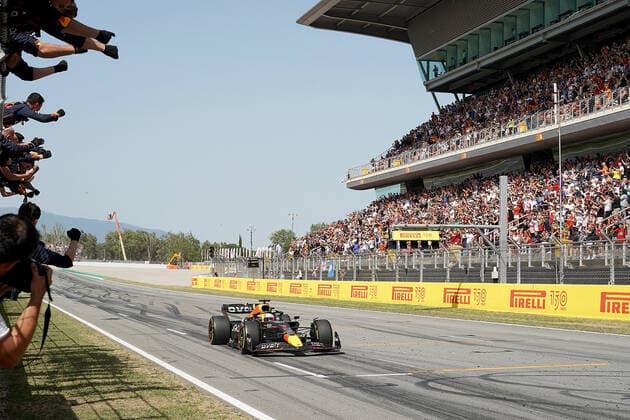 F1 Aramco Grand Prix von Spanien 2022 22.05.2022, Circuit de Catalunya, Barcelona, F1 Aramco Grand Prix von Spanien 2022 , im Bild Zieldurchfahrt des Siegers Max Verstappen (NEL), Oracle Red Bull Racing. seine Mechaniker jubeln ihm auf dem Zaun zu.