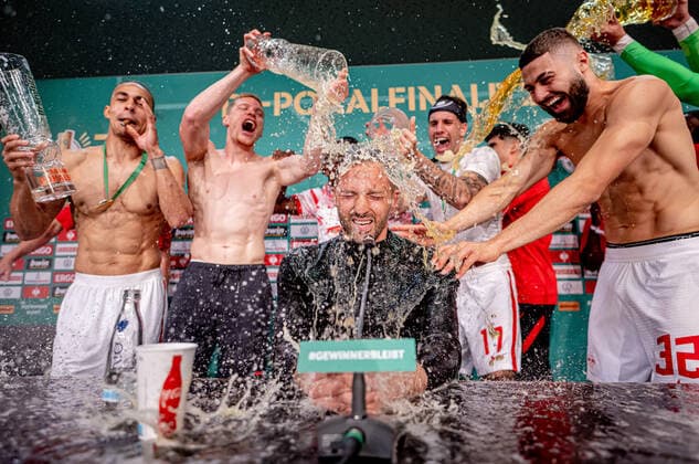 Leipzigs Spieler verpassen Cheftrainer Trainer Coach Domenico Tedesco auf der Pressekonferenz eine Bierdusche. DFB-Pokalfinale 2022 SC Freiburg - RB Leipzig 2:4 i.E.. 21. Mai 2022 Olympiastadion, Berlin. SC Freiburg - RB Leipzig 2:4 i.E.