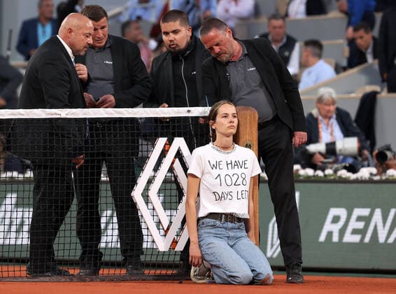 A climate activity is tied to the net during the semi-final match between Marin Cilic of Croatia and Norway s Casper Ruud s at the French Tennis Open in Roland Garros near Paris, France, on Friday, June 3, 2022. The 22-year-old woman who wore a T-shirt that read We have 1028 days left, pushing the world to act on climate change, was removed from the court by security.  PAR20220603160 MAYAxVIDON-WHITE