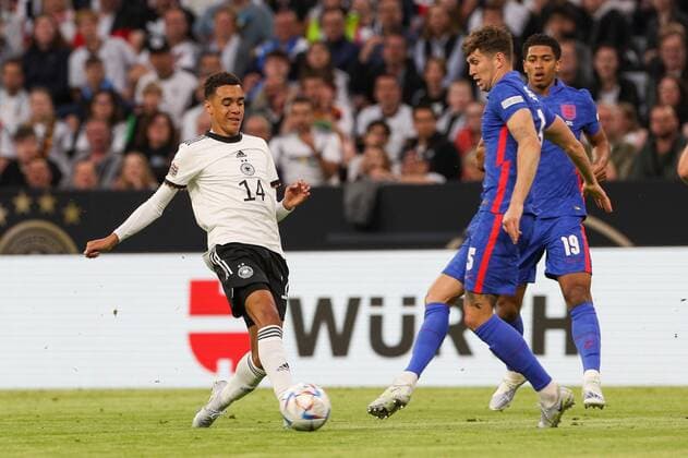 im Zweikampf, Aktion, mit Jamal Musiala 14 (Deutschland), John Stones 5 (England), Deutschland vs. England, UEFA, Nations League, Fussball, 07.06.2022 Muenchen Bayern Deutschland