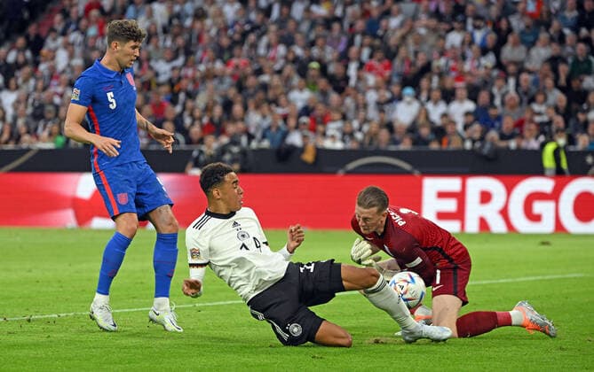 07.06.2022, xjhx, Fussball UEFA Nations League, Deutschland - England emspor, v.l. John Stones (England) Jamal Musiala (Deutsche Fussball Nationalmannschaft DFB) Jordan Pickford (England) Zweikampf, Aktion, action, battle for the ball (DFL DFB REGULATIONS PROHIBIT ANY USE OF PHOTOGRAPHS as IMAGE SEQUENCES and or QUASI-VIDEO) München