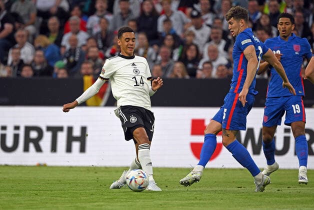 07.06.2022, xjhx, Fussball UEFA Nations League, Deutschland - England emspor, v.l. Jamal Musiala (Deutsche Fussball Nationalmannschaft DFB) John Stones (England) Zweikampf, Aktion, action, battle for the ball (DFL DFB REGULATIONS PROHIBIT ANY USE OF PHOTOGRAPHS as IMAGE SEQUENCES and or QUASI-VIDEO) München