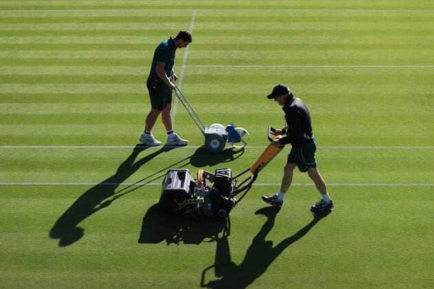 Sport Bilder des Tages Tennis - Wimbledon (Day 1) 27th June 2022 - Tennis - Wimbledon (Day 1) - Grounds staff mow the grass and paint the lines before the start of play - Photo: Simon Stacpoole Offside. London UK Copyright: xSimonxStacpoolexOffside