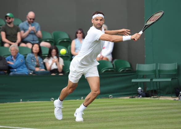 Bulgarian Grigor Dimitrov plays a backhand in his first round match against American Steve Johnson on day two of the 2022 Wimbledon championships in London on June 28, 2022.  LON2022062803 HUGOxPHILPOTT