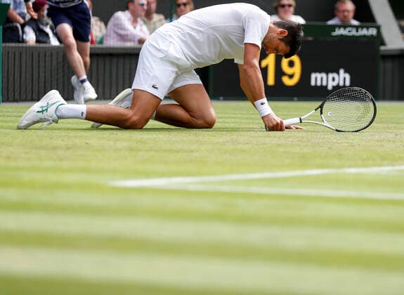 (220702) -- LONDON, July 2, 2022 -- Novak Djokovic falls onto the ground during the men s singles third round match between Novak Djokovic of Serbia and Miomir Kecmanovic of Serbia at Wimbledon Tennis Championship in London, Britain, on July 1, 2022. ) (SP)BRITAIN-LONDON-TENNIS-WIMBLEDON-MEN S SINGLES HanxYan 