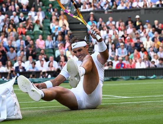 Sport Bilder des Tages Tennis Championships - Week One - Day Eight - All England Lawn Tennis Club, Wimbledon - Monday 4th July 2022 Rafael Nadal v Botic van de Zandschulp Rafa Nadal of Spain slips over on the grass on Centre Court 