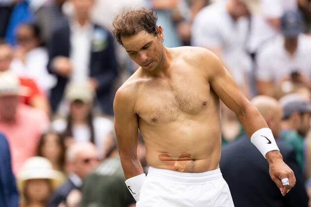 Mandatory Credit: Photo by Ella Ling Shutterstock (13018040ba) Rafael Nadal with tape on a stomach injury during his quarter final match Wimbledon Tennis Championships, Day 10, The All England Lawn Tennis and Croquet Club, London, UK - 06 Jul 2022 Wimbledon Tennis Championships, Day 10, The All England Lawn Tennis and Croquet Club, London, UK - 06 Jul 2022  Copyright: xEllaxLing Shutterstockx 13018040ba