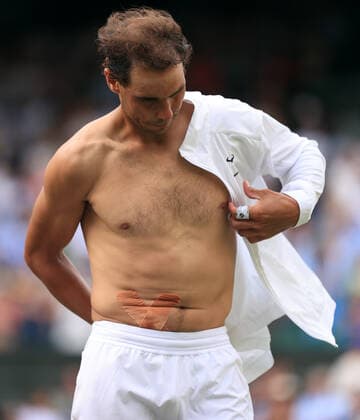 Tennis - Wimbledon (Day 10) 6th July 2022 - Tennis - Wimbledon (Day 10) - Rafael Nadal v Taylor Fritz - Nadal removes his shirt after victory revealing the tape for his abdominal injury. Photo: Simon Stacpoole Offside. London UK Copyright: xSimonxStacpoolexOffside