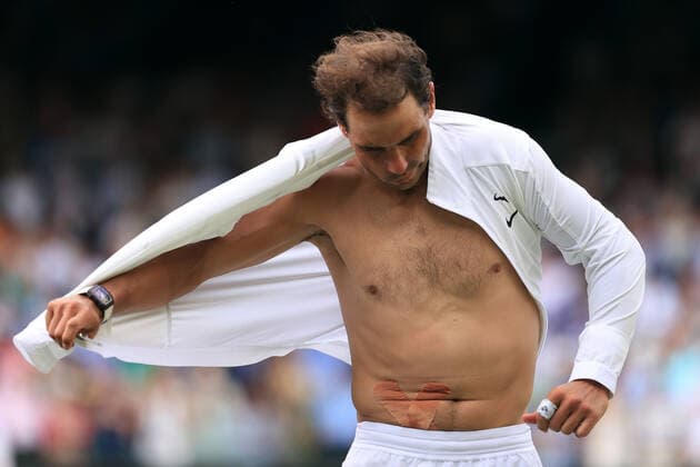 Tennis - Wimbledon (Day 10) 6th July 2022 - Tennis - Wimbledon (Day 10) - Rafael Nadal v Taylor Fritz - Nadal removes his shirt after victory revealing the tape for his abdominal injury. Photo: Simon Stacpoole Offside. London UK Copyright: xSimonxStacpoolexOffside