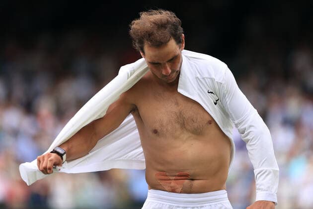 Sport Bilder des Tages Tennis - Wimbledon (Day 10) 6th July 2022 - Tennis - Wimbledon (Day 10) - Rafael Nadal v Taylor Fritz - Nadal removes his shirt after victory revealing the tape for his abdominal injury. Photo: Simon Stacpoole Offside. London UK Copyright: xSimonxStacpoolexOffside