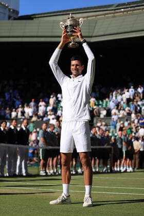 Tennis - Wimbledon (Day 14) 10th July 2022 - Tennis - Wimbledon (Day 14) - Novak Djokovic (SRB) holds the trophy aloft as he celebrates victory over Nick Kyrgios (AUS) in their Gentlemen s Singles Final - Photo: Simon Stacpoole Offside. London UK Copyright: xSimonxStacpoolexOffside