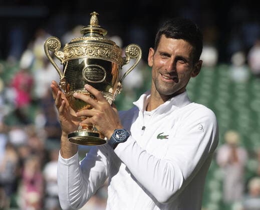 Serbian Novak Djokovic holds the Wimbledon trophy after victory in the Men s Final match against Australian Nick Kyrgios on day fourteen of the 2022 Wimbledon championships in London on Sunday, July 10, 2022. Djokovic won the match 4-6,6-3,6-4,7-6.  LON2022071030 HUGOxPHILPOTT